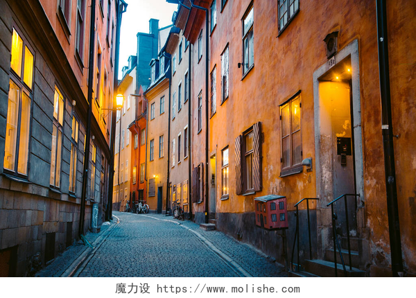 黄昏时分的城市道路在瑞典斯德哥尔摩市中心的黄昏时分，斯德哥尔摩历史名城甘姆拉斯坦（旧城）美丽的小巷里，传统房屋的景观在黄昏时分闪烁着光芒